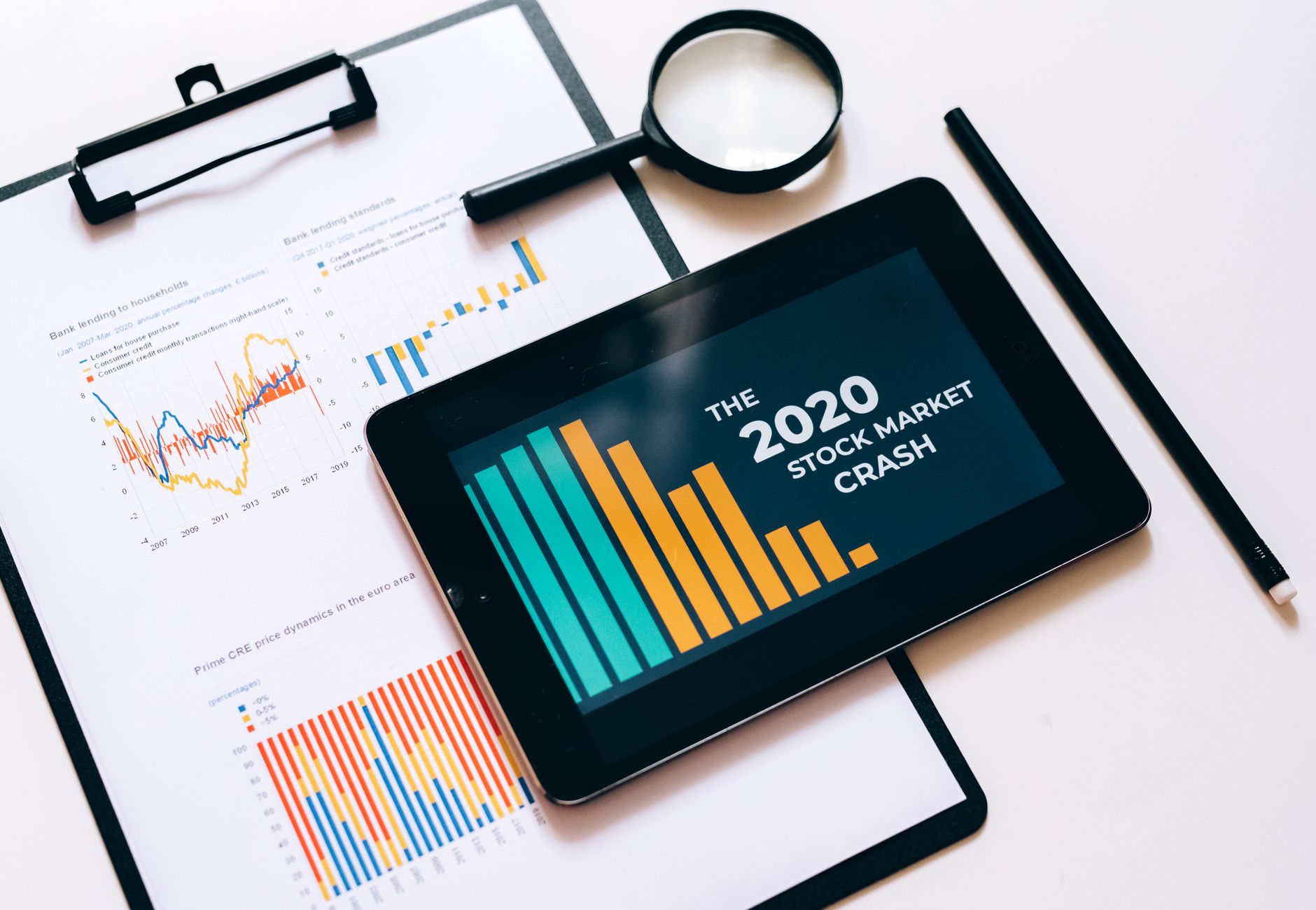 Close-up of financial graphs and digital tablet highlighting 2020 stock market crash.