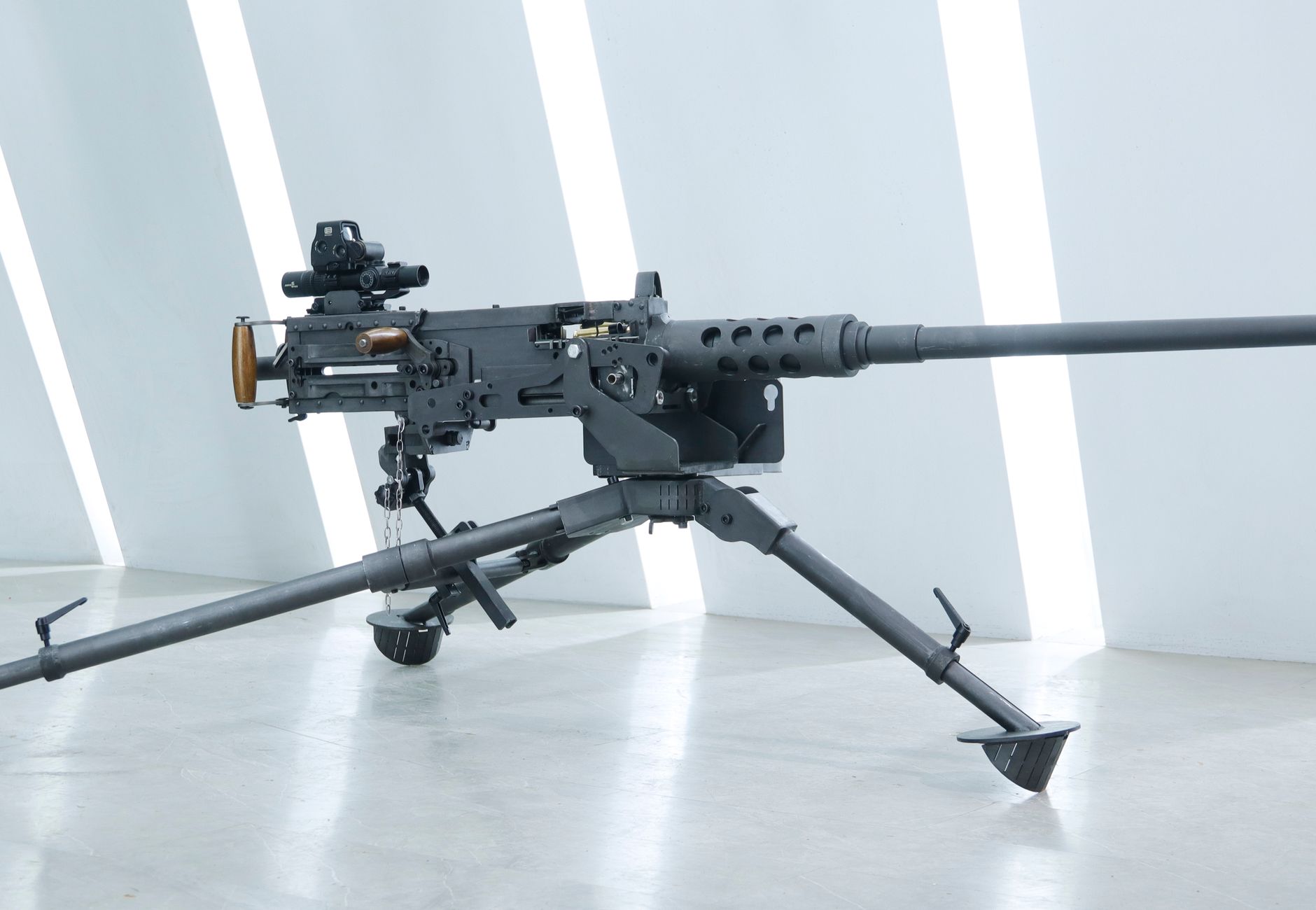 Close-up of a mounted black military machine gun in an indoor setting.